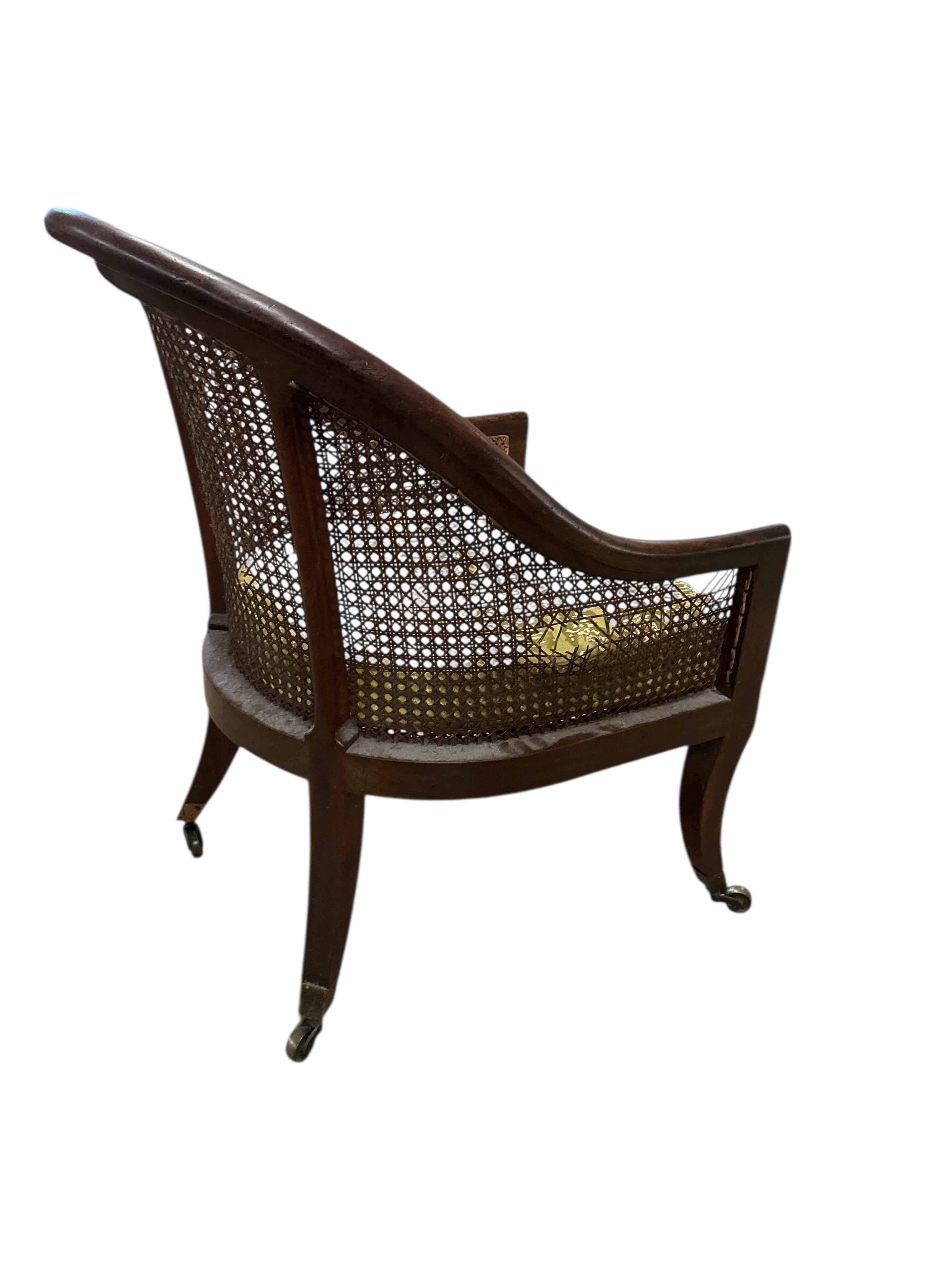 A Regency mahogany caned bergere armchair, (damaged cane) together with a Regency simulated rosewood and brass caned bergere armchair, larger width 49cm, depth 60cm, height 83cm